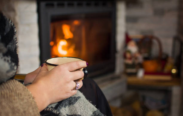 istock Woman drinking mulled wine by the fireplace 891809870