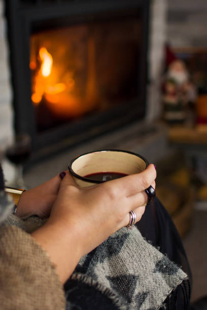 istock Woman drinking mulled wine by the fireplace 891809972