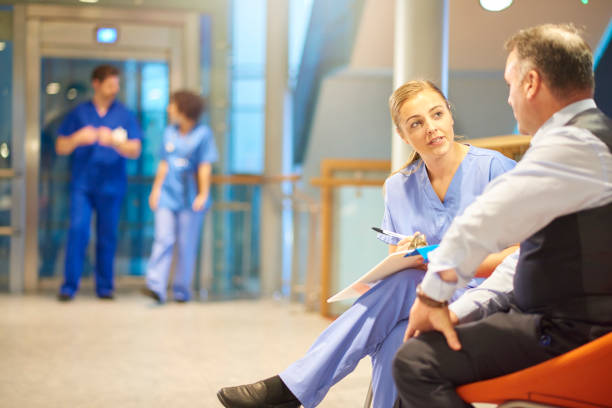 istock nurse filling out paperwork with patient 891815064