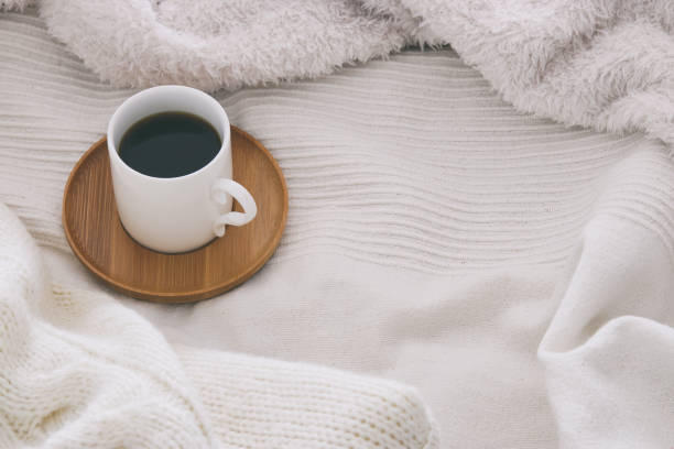 istock Cup of coffee over cozy and white blanket. Top view. 891832446