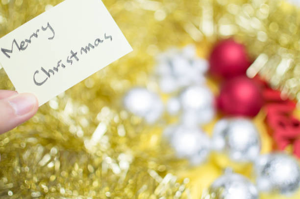 istock Merry christmas writen on yellow sheet : christmas decorations background 891838392