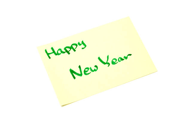istock Happy new year writen on yellow sheet, white background 891840958