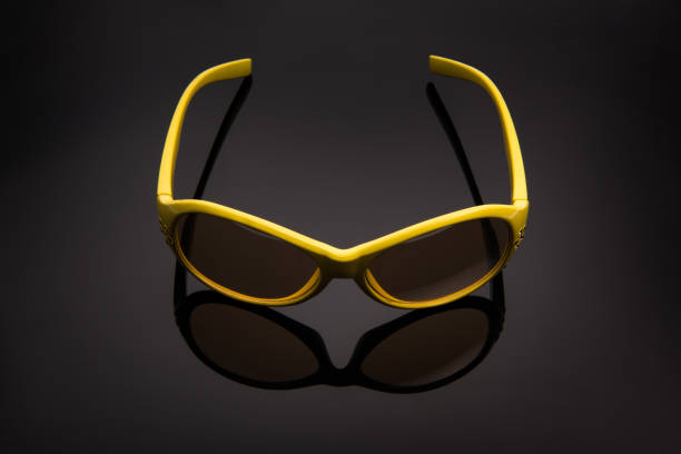 istock The yellow sunglasses on the black background. 891843560