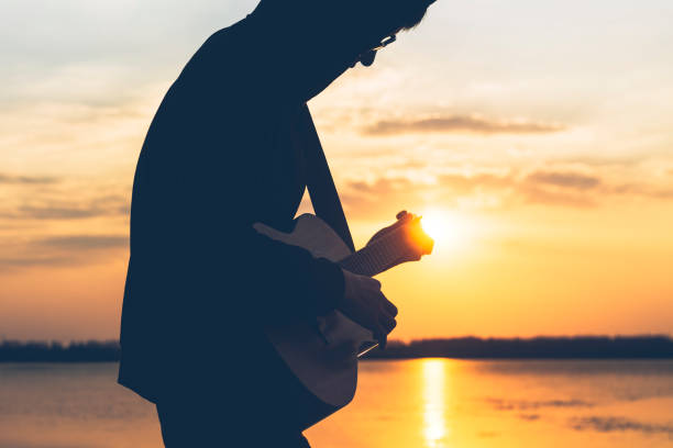 istock silhouette of man with guitar against sunset sky 891843756