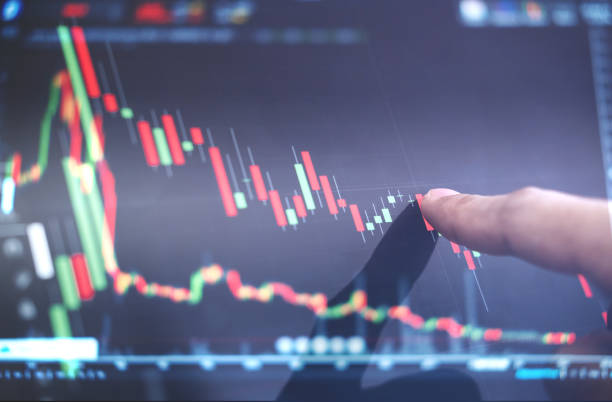 istock Finger pointing on stock exchange market chart 891848748