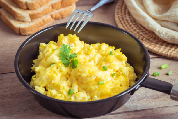 istock Scrambled egg in frying pan and toast on wooden table 891866820
