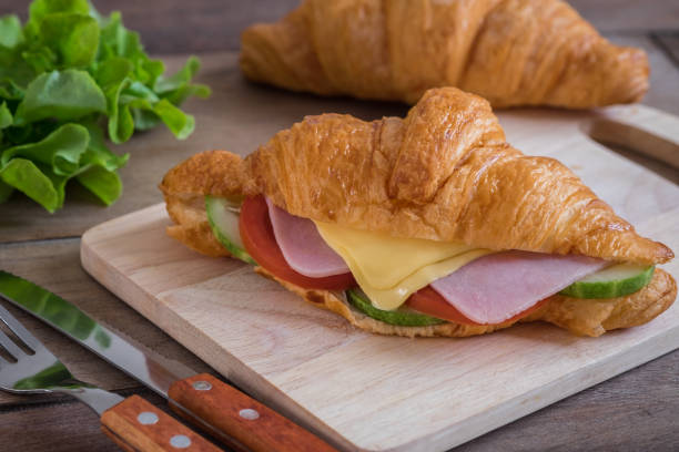 istock Croissant with ham, cheese on wooden board 891866824