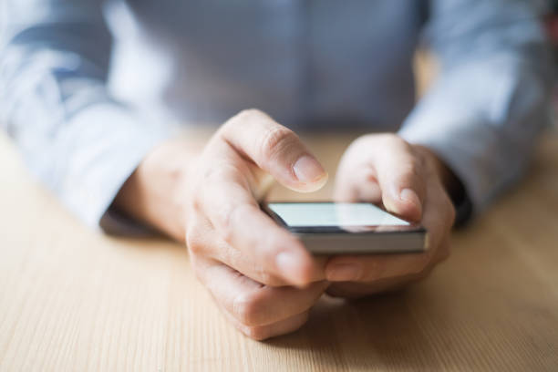istock Closeup of Person Using Smartphone at Desk 891872588