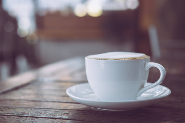 istock Hot coffee in white cup on wooden table 891879972