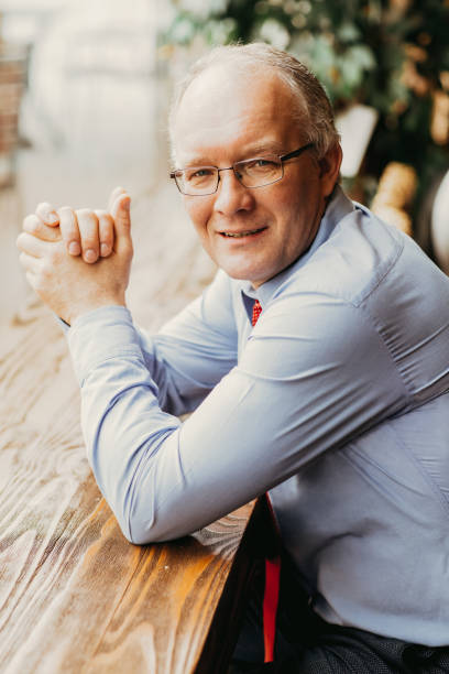 istock Content Middle-aged Man Sitting at Cafe Counter 891882610