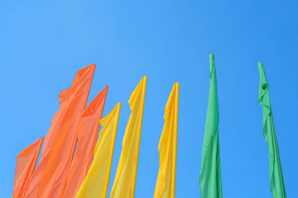 many colorful flags waving over the blue sky background