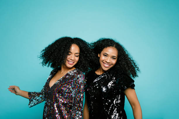 istock Smiling women dancing over blue background in studio 891906858
