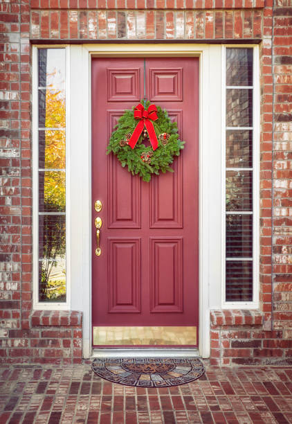 balsam fir christmas wreath on a red door - doormat door christmas holiday imagens e fotografias de stock