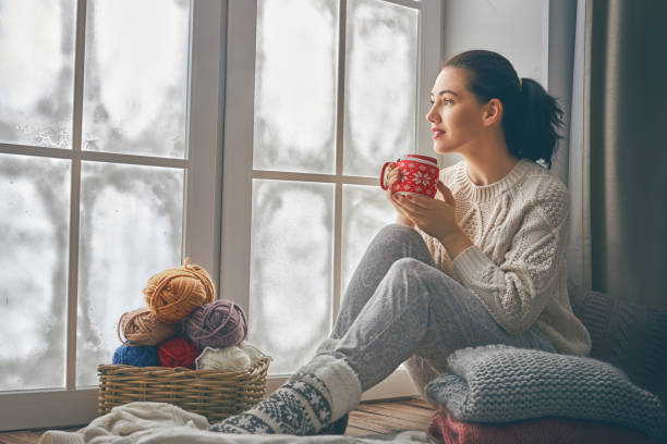 istock woman sitting by the window 891926306