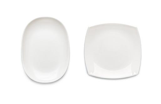 Two white plates of different shapes on a white background. View from above. Isolated.