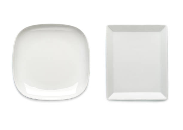 istock Two white plates of a square shape on a white background. View from above. Isolated. 891931236