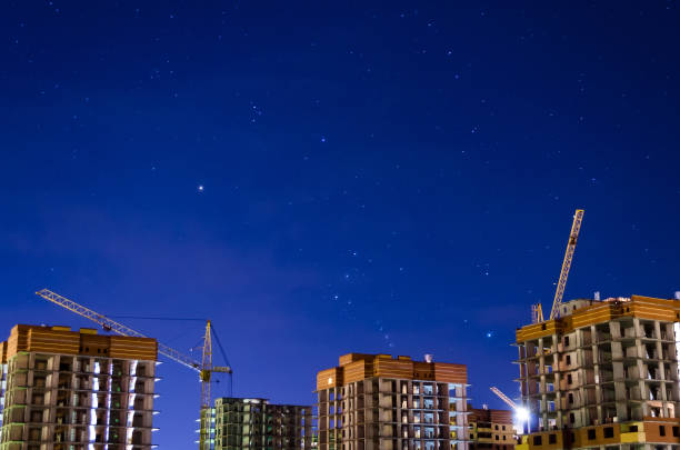 istock Industrial construction night city crane night stars sky. 891940194