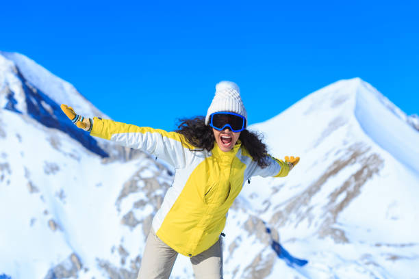 istock Smiling young woman having fun in the snow mountain 891945484