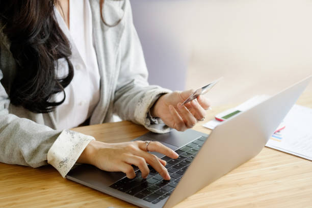 istock Young woman looking credit card and using laptop computer. Online shopping concept 891950088