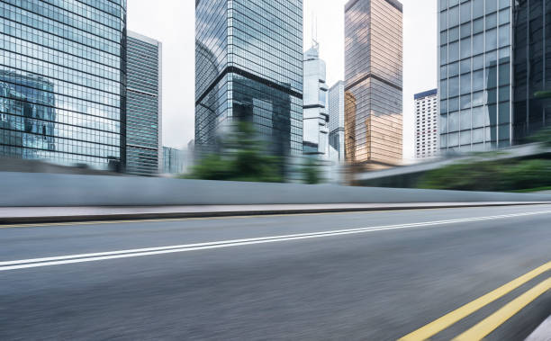 istock modern buildings and empty road against cloudy sky 891953170