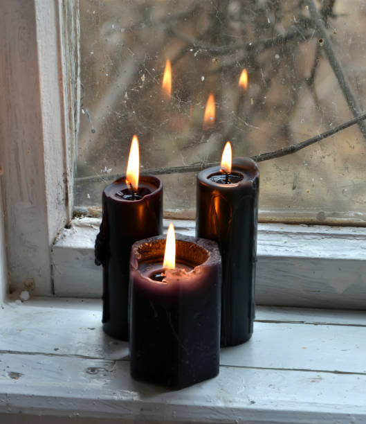 istock Burning black candles against the old window 891956106