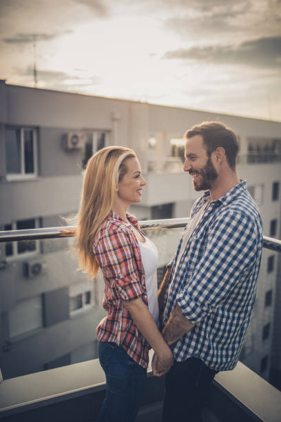 istock Loving couple holding hands and communicating on a penthouse terrace. 891961392