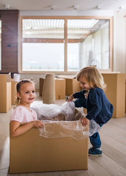 istock Happy kids having fun with cardboard box in their new apartment. 891966230