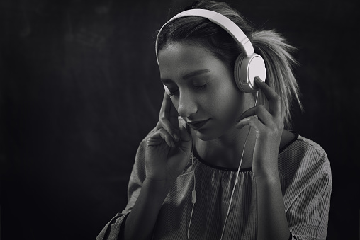 young woman listening music and dancing with headphone