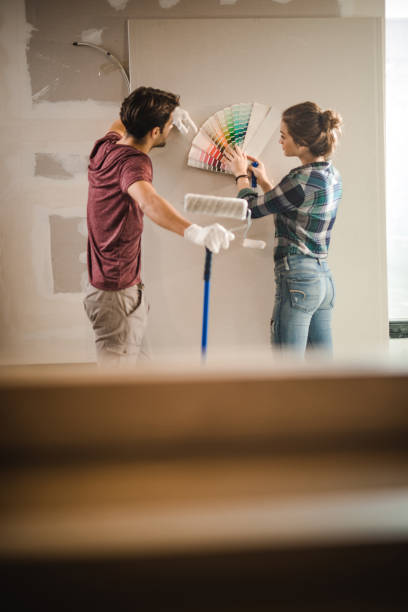 молодая пара выбирает правильный цвет для своей стены в новой квартире. - home addition plasterboard home improvement home interior стоковые фото и изображения
