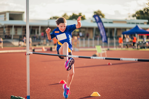 Little girl is training for the high jump at athletics club.