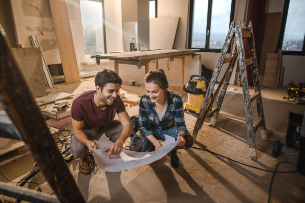 istock Happy couple looking at their housing project on construction site. 891972624