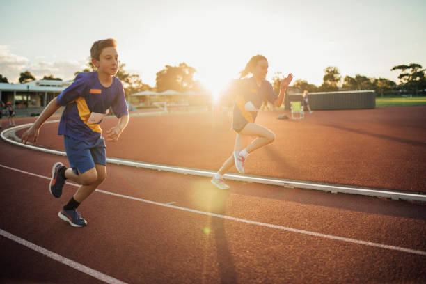Girls Running Race Two girls are racing each other on the running track at athletics club. sports training australia stock pictures, royalty-free photos & images