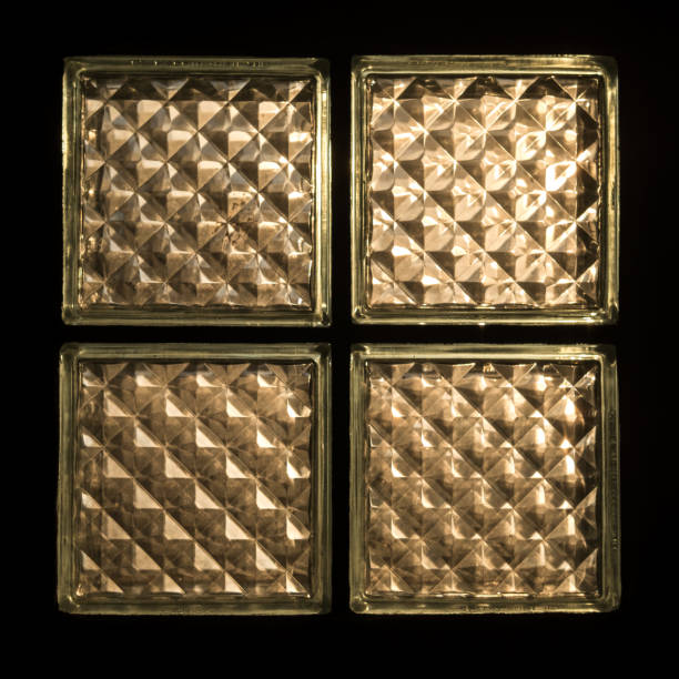 istock Closeup image of four glass blocks with black wall background 891978630