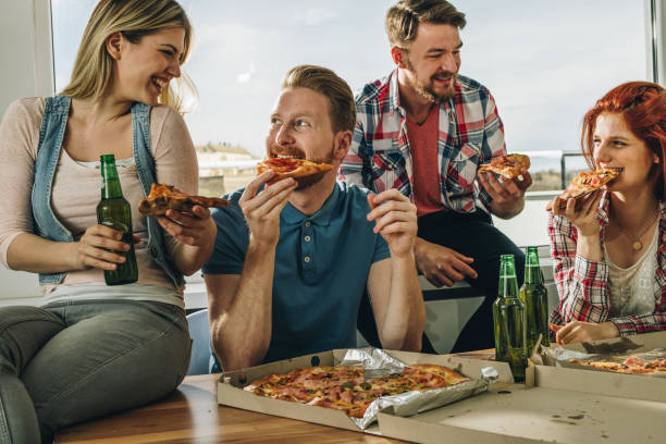 istock Happy friends talking and having fun while eating pizza at home. 891982152