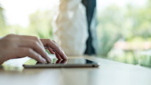 istock Closeup image of a woman's hands typing , touching and using tablet pc  on wooden table in cafe 891982410