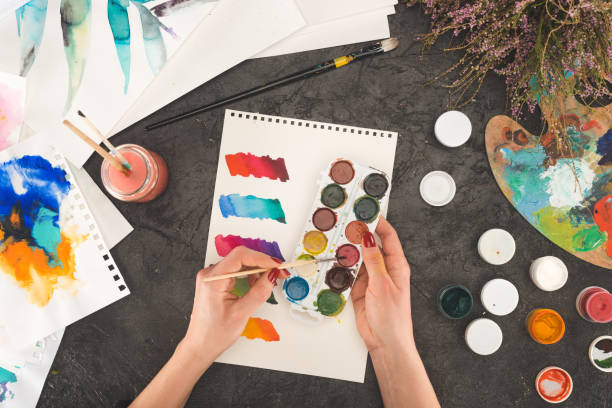 istock artist mixing watercolor paints 891982436