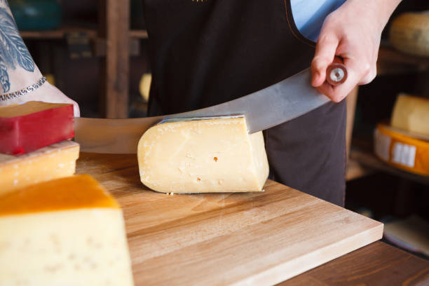 istock Cutting hard cheese in grocery shop 891982810