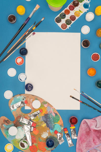 istock empty sheet of paper and brushes with paints 891991412