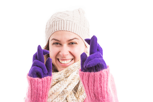 Woman wearing winter clothes making good luck gesture with fingers crossed smilling happy and joyful for the camera isolated on white studio background