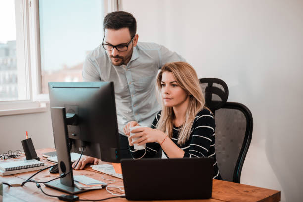 istock Two business people co working with a computer on a desk at office. 891996594