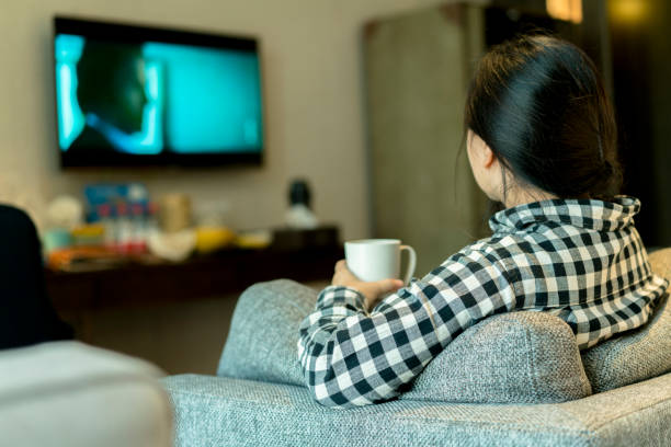 istock girl watching TV and drinking water 892005582