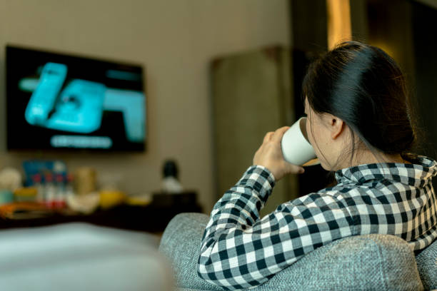 istock girl watching TV and drinking water 892005694