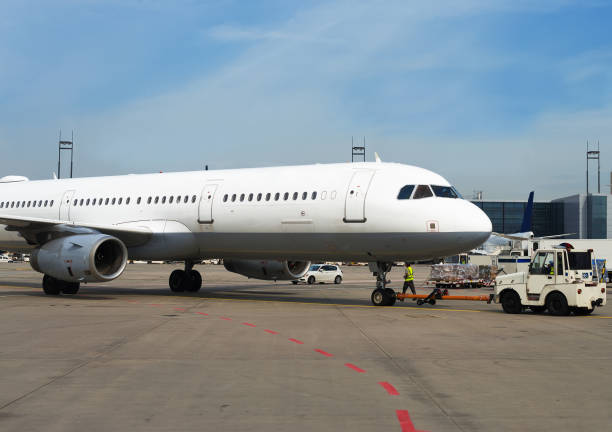 istock TUG Pushback tractor with Aircraft on the runway in airport. 892029204