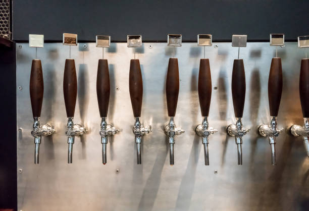 istock taps for beer bottling and other drinks on silver metal background 892032506