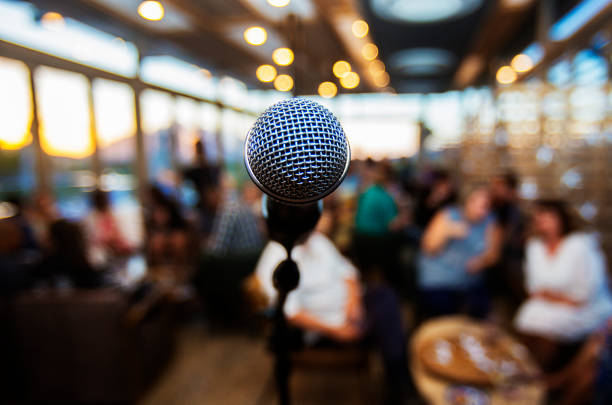 Microphone infront of out of focus  people waiting Microphone infront of out of focus  people waiting keynote speech stock pictures, royalty-free photos & images