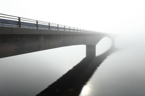 Concrete bridge over the sea in the middle of a deep fog
