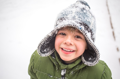 Winter fun, kid winter playing -cute boy has a fun in snow