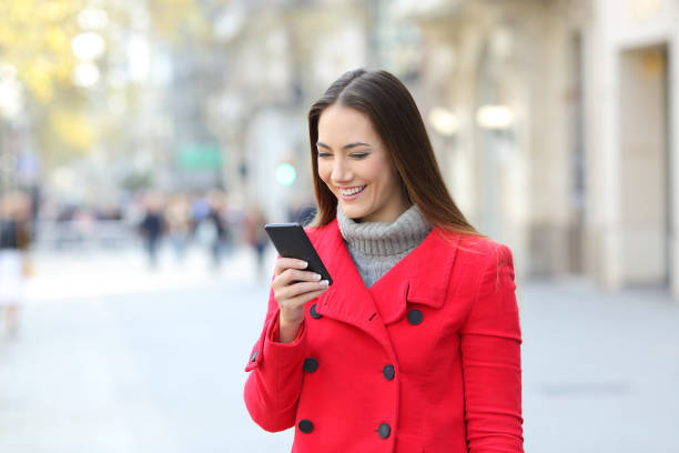 istock Lady using a smart phone on the street in winter 892038710