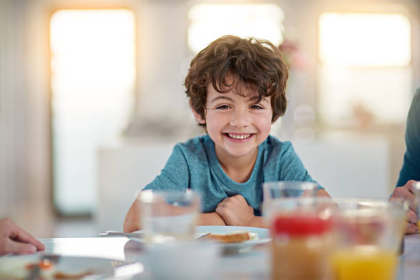 I love me some breakfast Cropped portrait of an adorable little boy eating breakfast while sitting at the dining room table breakfast room photos stock pictures, royalty-free photos & images