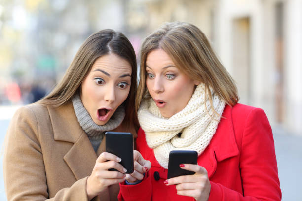 istock Two amazed women finding content on phones 892039164